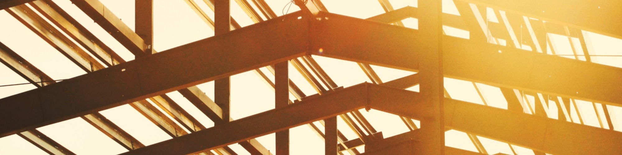 Busy construction site with workers in hard hats, heavy machinery, and scaffolding, showcasing the diverse roles we hire for in the construction industry